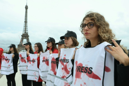 Des membres de RSF tiennent des gilets de presse tâchés de sang lors d'une action en soutien aux journalistes travaillant dans la bande de Gaza, à Paris le 26 septembre 2024