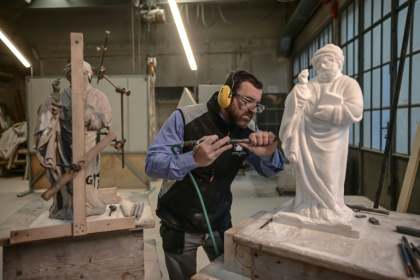 Giovanni Calderino sculpte une statue avec un marteau pneumatique dans l'atelier du marbre à Milan, le 11 décembre 2024