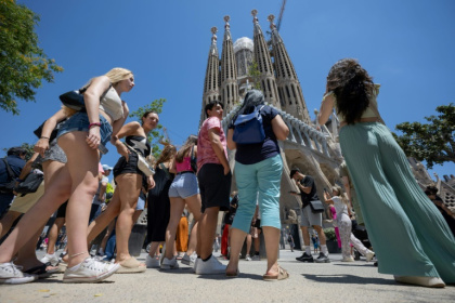 Des touristes devant la basilique Sagrada Familia à Barcelone le 5 juillet 2024