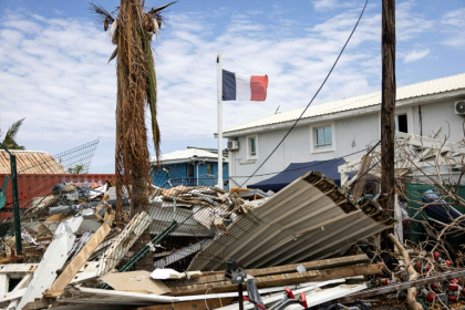 Le drapeau français flotte au-dessus des décombres à Dzaoudzi, à Mayotte, le 28 décembre 2024, après le passage du cyclone Chido deux semaines plus tôt