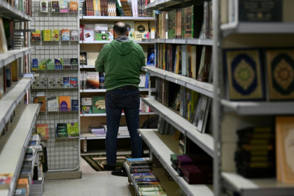 Un employé prie dans une allée d'une librairie à Damas, le 26 janvier 2025