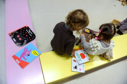 Des enfants de deux ans regardent un livre à Firmi, le 14 janvier 2013