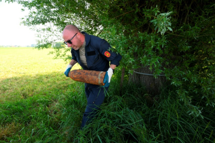 Un membre de l'équipe de déminage de la DOVO ramasse de vieux obus de la Première Guerre mondiale trouvés dans la campagne du nord-ouest de la Belgique, près d'Ypres, le 19 mai 2025 - Nicolas TUCAT (AFP)