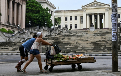 Un couple pousse un chariot avec de la nourriture devant l'Université de La Havane, à Cuba, le 4 juin 2025 - YAMIL LAGE (AFP) Un couple pousse un chariot avec de la nourriture devant l'Université de La Havane, à Cuba, le 4 juin 2025 - YAMIL LAGE (AFP)