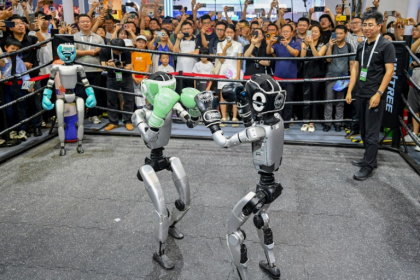 Des visiteurs regardent un combat de boxe entre robots lors de la World AI Conference (WAIC), le 26 juillet 2025 à Shanghai - - (AFP)