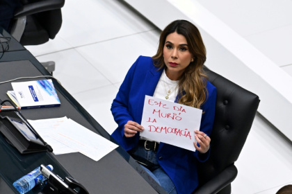 La députée d'opposition Macela Villatoro brandit une pancarte avec a phrase "la démocratie est morte aujourd'hui" pendant l'examen par le Parlement d'une réforme permettant la réélection indéfinie du président, le 31 juillet 2025 - Marvin RECINOS (AFP)