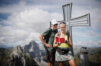 Patrick et Cathy, lisent le "Tinder des montagnes" au sommet de la Wandflue dans le canton de Fribourg, en Suisse, le 3 août 2025 - GABRIEL MONNET (AFP)