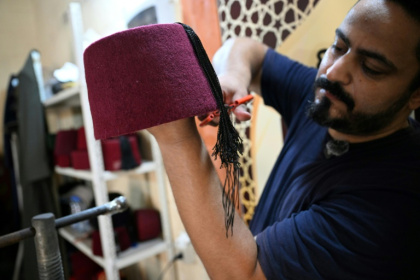 Mohammed Al-Shaar, dernier confectionneur de tarbouches du Liban, travaille dans son atelier à Tripoli dans le nord du pays, le 6 août 2025 - Joseph EID (AFP)
