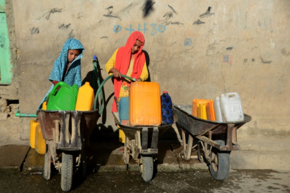 Des jeunes filles remplissent des jerrycans avec de l'eau potable à Kandahar, le 24 mai 2022 en Afghanistan - Javed TANVEER (AFP)