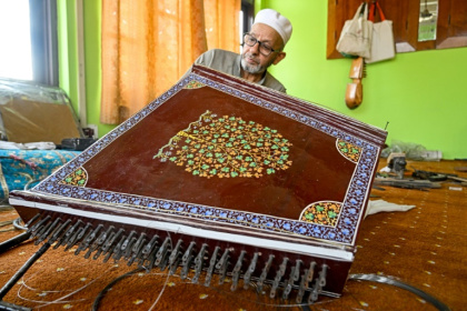 L'artisan Ghulam Mohammad Zaz fabrique un santour, un instrument à cordes ancestral, dans son atelier à Srinagar, le 23 septembre 2025 au Cachemire indien - Tauseef MUSTAFA (AFP)
