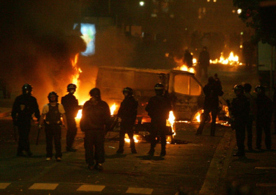 Des policiers devant des véhicules incendiés, le 28 octobre 2005 à Clichy-sous-Bois, en Seine-Saint-Denis, où de nouvelles violences urbaines ont éclaté entre des jeunes des quartiers difficiles et les forces de l'ordre - Joël SAGET (AFP)