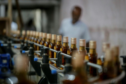 Des bouteilles de whisky Imperial sur une ligne de production à la distillerie Carew and Co. à Darsana, le 23 octobre 2025 dans le sud-ouest du Bangladesh - Rehman ASAD (AFP)