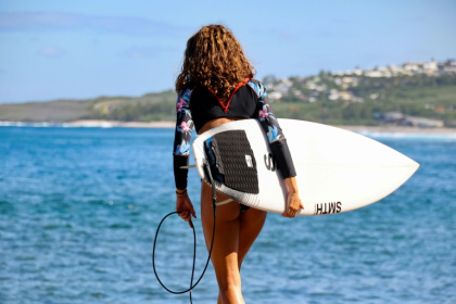 Une surfeuse tient sa planche équipée d'un dispositif antirequins, à Saint-Leu, à La Réunion, le 2 avril 2021 - Richard BOUHET (AFP)