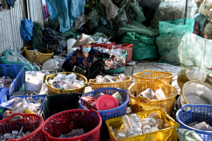 Une femme trie des déchets n plastique près de Hanoï, au Vietnam, le 25 novembre 2025 - Nhac NGUYEN (AFP)