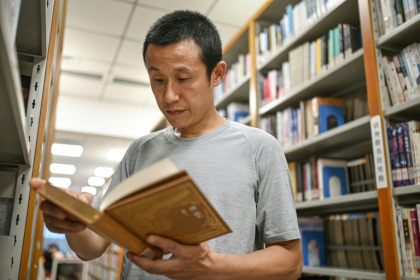Hu Anyan, ancien livreur devenu auteur à succès, dans une bibliothèque à Chengdu, en Chine, le 18 août 2025 - Jade GAO (AFP)
