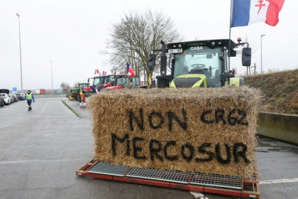 Une botte de foin "Non au Mercosur" sur un tracteur alors que des agriculteurs participent à un blocage sur l'autoroute A1 près de Fresnes-lès-Montauban, le 12 janvier 2026 dans le Pas-de-Calais - Lou BENOIST (AFP)