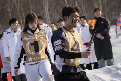 Un joueur porte une toche lors de la cérémonie d'ouverture d'un tournoi international de "yukigassen" à Sobetsu, sur l'île septentrionale japonaise d'Hokkaido, le 21 février 2026 - Yuichi YAMAZAKI (AFP)