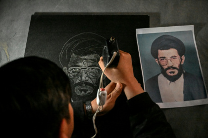 L'artiste Sadiq Poya grave le portrait d'une personne décédée sur une pierre tombale à Quetta, au Pakistan, le 17 février 2026 - Banaras KHAN (AFP)