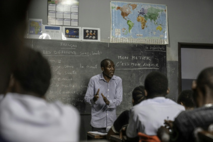 Alphonse (au centre), professeur de français, donne des cours à d'anciens enfants des rues au centre de formation de l'ONG OSEPER à Kinshasa, capitale de la République démocratique du Congo, le 24 février 2026 - Glody MURHABAZI (AFP)