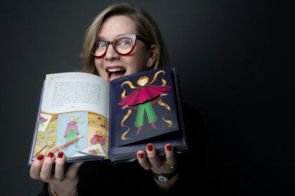 Miraphora Mina du studio MinaLima pose avec le nouvel album du "Petit Prince", le 2 avril 2026 à Paris - JOEL SAGET (AFP)