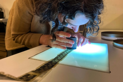 Courtney Holschuh utilise une loupe pour regarder la pellicule d'un film, au Centre national de conservation audiovisuelle de la Bibliothèque du Congrès à Culpeper, le 2 avril 2026 en Virginie - Kent Nishimura (AFP)