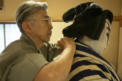 Le maître perruquier Tadashi Kamoji (g) aide l'acteur Tanenosuke Nakamura à mettre sa perruque avant une représentation au théâtre Kabuki-za à Tokyo, le 13 avril 2026 - Yuichi YAMAZAKI (AFP)