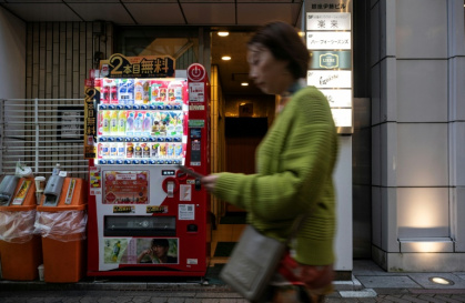Une femme passe devant un distributeur automatique, le 7 avril 2026 à Tokyo - Andrew CABALLERO-REYNOLDS (AFP)