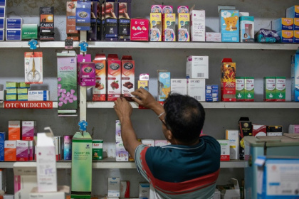 Un employé range les boîtes de préservatifs dans une pharmacie à Dacca, au Bangladesh, le 27 avril 2026 - Salahuddin Ahmed (AFP)
