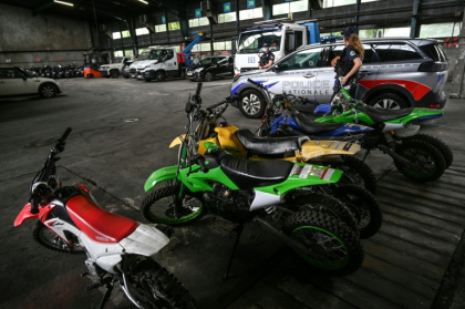 Des policiers se tiennent près de motos saisies après des rodéos urbains, le 13 juillet 2021 à Lyon - PHILIPPE DESMAZES (AFP)