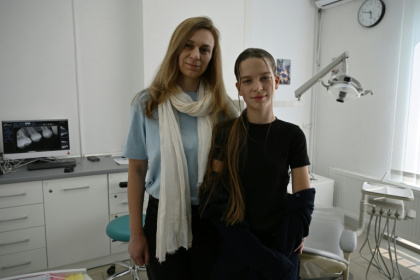 Les réfugiées ukrainiennes Iana Sidko et sa fille Daryna posent dans un clinique dentaire pour enfants à Kiev, en Ukraine, le 30 avril 2026 - Genya SAVILOV (AFP)