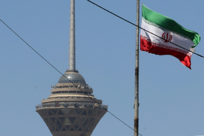 Un drapeau iranien flotte près de la tour Milad, le 25 mai 2026 à Téhéran - ATTA KENARE (AFP)