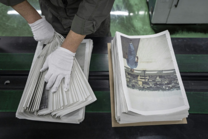 Un employé emballe l'œuvre du photographe Kazuma Obara, "The Newspaper", à Kumiyama, dans la préfecture de Kyoto, au Japon, le 19 mars 2026 - Yuichi YAMAZAKI (AFP)