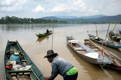 Le pêcheur Somdet Singthong pousse son bateau dans le Mékong, près de Chiang Saen, dans le nord de la Thaïlande, le 4 juin 2026 - Lillian SUWANRUMPHA (AFP)