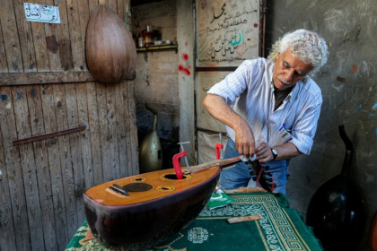 Le luthier palestinien Souhail Abou Chawich dans son atelier de réparation d'ouds, au camp de réfugiés de Nousseirat, dans le centre de la bande de Gaza, le 23 juin 2026 - Eyad Baba (AFP)