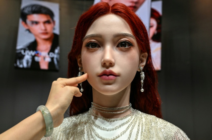 Une femme touche la peau d'un robot androïde U1 présenté à Shenzen, le 30 juin 2026 dans la province chinoise du Guangdong - ADEK BERRY (AFP)