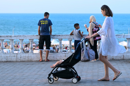Une femme promène son enfant en poussette à La Marsa, près de Tunis, le 28 juillet 2026 - FETHI BELAID (AFP)