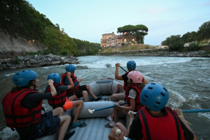 Des personnes naviguent en canot pneumatique sur le Tibre, passant devant l'île Tibérine, sur un tronçon du fleuve situé entièrement dans la zone urbaine du centre de Rome, le 14 août 2026 - Andreas SOLARO (AFP)